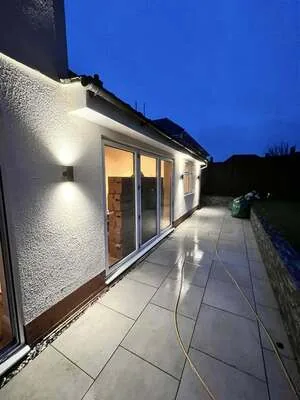 Rendered rear extension with up and down wall lights along the patio