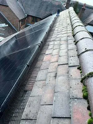 Black solar panels installed along a pitched tiled roof