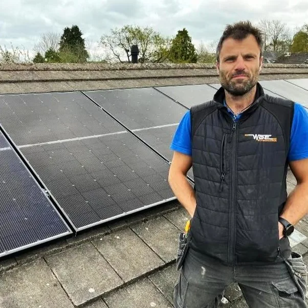 One of our electricians in Sutton Coldfield on a roof beside newly installed solar panels